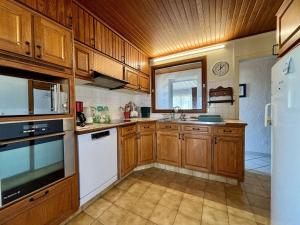 a kitchen with wooden cabinets and white appliances at Maison 4 pièces à Oléron avec WIFI et jardin proche plage - FR-1-246A-322 in Saint-Pierre-dʼOléron