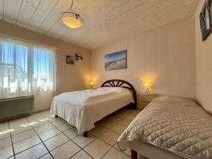 a bedroom with two beds and a window at Maison 4 pièces à Oléron avec WIFI et jardin proche plage - FR-1-246A-322 in Saint-Pierre-dʼOléron