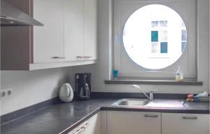 a kitchen with a sink and a round window at Residence Helena in Ostend