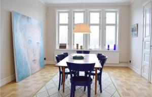 a dining room with a table and chairs and a painting at Awesome Home In Listerby With Kitchen in Listerby
