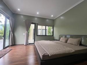 a bedroom with a large bed and a large window at Lake House in Ha Giang
