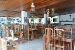 a restaurant with wooden ceilings and tables and chairs at Jacumã´s Lodge Hotel in Jacumã