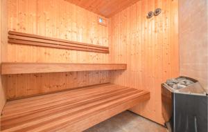 a sauna with wooden walls and wooden shelves at Holiday Home Granvej Rømø Ii in Bolilmark