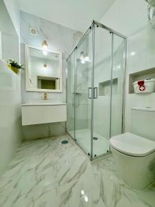 a bathroom with a glass shower and a toilet at Casinha da Patricia in Nazaré