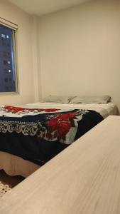 a bedroom with two beds and a window at Quarto em apartamento no Centro in Passo Fundo
