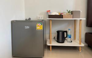 a small refrigerator next to a shelf with a coffee maker at Arawan Resort เอราวัณ รีสอร์ท in Ngao