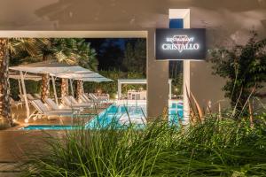 a sign for a hotel with chairs and a pool at Resort Miramonti in Forte dei Marmi