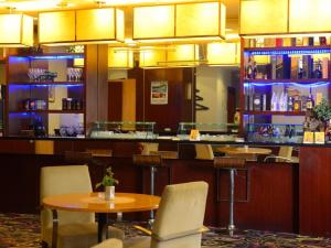 a restaurant with a table and chairs and a bar at Xiamen Fortune Hotel in Xiamen