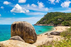 a rock on a beach with the ocean at Tanote Good View in Ko Tao