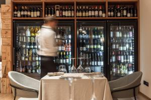 a man standing behind a bar with a table at Resort Miramonti in Forte dei Marmi