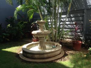 a large stone fountain in the middle of a yard at Hotel Brandts Ejecutivo Los Robles in Managua