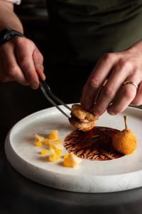 a person cutting up a piece of food on a plate at Resort Miramonti in Forte dei Marmi