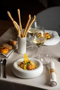 a table with a plate of food and glasses of wine at Resort Miramonti in Forte dei Marmi