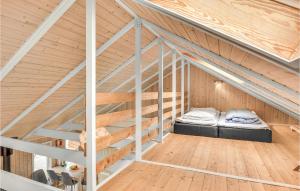 a bed in the attic of a wooden house at Lovely Home In Hemmet With Kitchen in Hemmet
