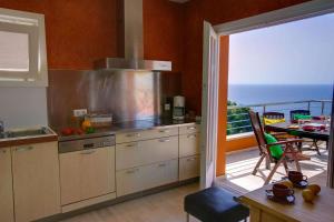 a kitchen with a view of a balcony with a table at Mar Bona in Tamariu