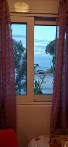 a window with a view of the ocean through it at Tsampikas House in Faliraki