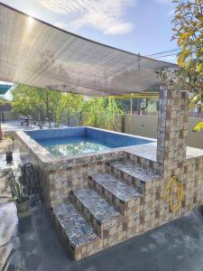 a swimming pool with a stone wall and some stairs at The Garden Homestay Kemaman in Kemaman