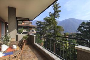 d'un balcon avec une table et une vue sur la montagne. dans l'établissement Appartamento Il Parco Cernobbio, à Cernobbio