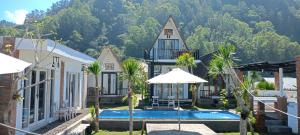a house with a swimming pool in front of a mountain at Batur Homestay and Lodge in Bangli