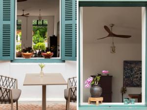 a dining room with blue shutters and a table at PHA NYA RESIDENCE in Luang Prabang +56 photos