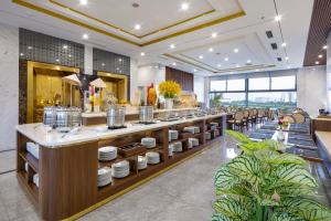 a restaurant with a counter with dishes on it at Avari Hotel in Nha Trang