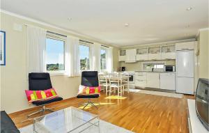 a living room with a table and chairs and a kitchen at Cozy Apartment In Straumsgrend in Bergen