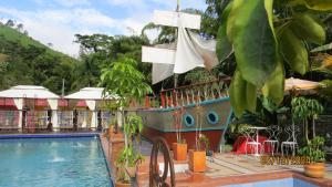 ein Resort mit Swimmingpool und Boot in der Unterkunft Balneario Hostal El Pacha in Líbano + 26 Fotos