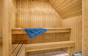 a wooden sauna with a blue towel in it at Cozy Home In Rømø With Sauna in Kongsmark +36 photos