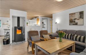 a living room with a table and a fireplace at Cozy Home In Rømø With Sauna in Kongsmark