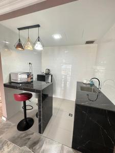 une cuisine avec un comptoir noir et un tabouret rouge dans l'établissement B 13a-7 De MARINA VIEW VILLAS, à Port Dickson