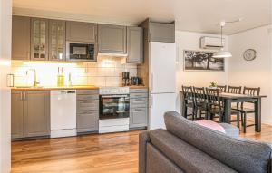 a kitchen and living room with a couch and a table at 3 Bedroom Gorgeous Home In Löttorp in Löttorp
