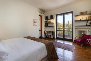 een slaapkamer met een bed en een kamer met een balkon bij Appartamento Il Parco Cernobbio in Cernobbio