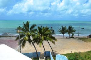 Blick auf einen Strand mit Palmen und das Meer in der Unterkunft Jacumã´s Lodge Hotel in Jacumã