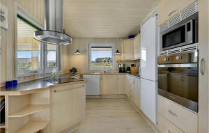 a kitchen with a white refrigerator and a sink at Holiday Home Karen Brands Vej Hvide Sande Iii in Hvide Sande