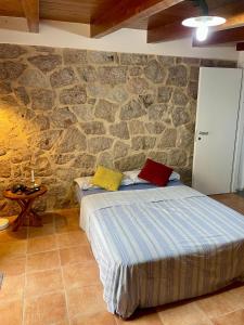 Un dormitorio con una cama y una pared de piedra. en Villa Dora, en Tottubella