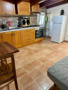 Una cocina con gabinetes de madera y un refrigerador blanco. en Villa Dora, en Tottubella