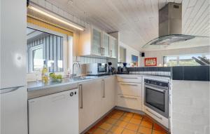 a large kitchen with white appliances and a window at Cozy Home In Hvide Sande With Sauna in Bjerregård