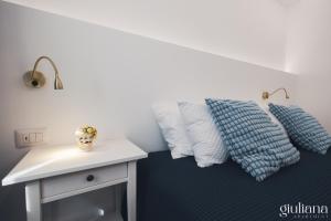 a bed with blue and white pillows and a table at Giuliana in Letojanni