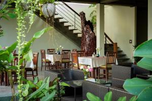 a restaurant with tables and chairs and a staircase at Khmer House Resort in Siem Reap