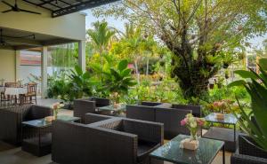a restaurant with tables and chairs and a garden at Khmer House Resort in Siem Reap