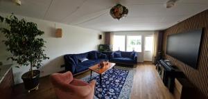 a living room with blue couches and a flat screen tv at Blå rummet - Rum i familjärt boende - Sängkläder & handdukar ingår in Färjestaden