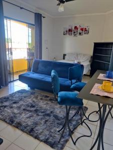 a living room with a blue couch and a table at Kitnet próximo ao parque exposições in Maringá