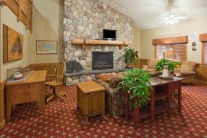 a large living room with a stone fireplace at AmericInn by Wyndham Wetmore Munising in Wetmore