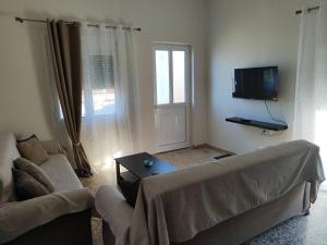 a living room with a couch and a tv at Odysseus family house in Stefaniá