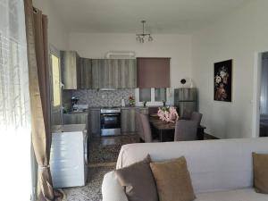 a living room with a couch and a kitchen at Odysseus family house in Stefaniá