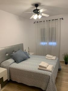 Un dormitorio con una cama y un ventilador de techo. en Apartamento HS Costa Castillo, en Poblado de Sancti Petri