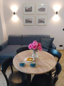 a table with a vase of flowers and a couch at Apartament przy Ratuszu in Płock