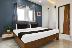 a bedroom with a large bed with blue walls at HOTEL O ANUSHTHAN in Jabalpur