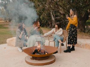 a group of women sitting around a fire pit at The Timothée Resort in Busselton +62 photos