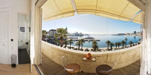 a room with a view of the ocean from a balcony at Riva Luxury Suites in Split